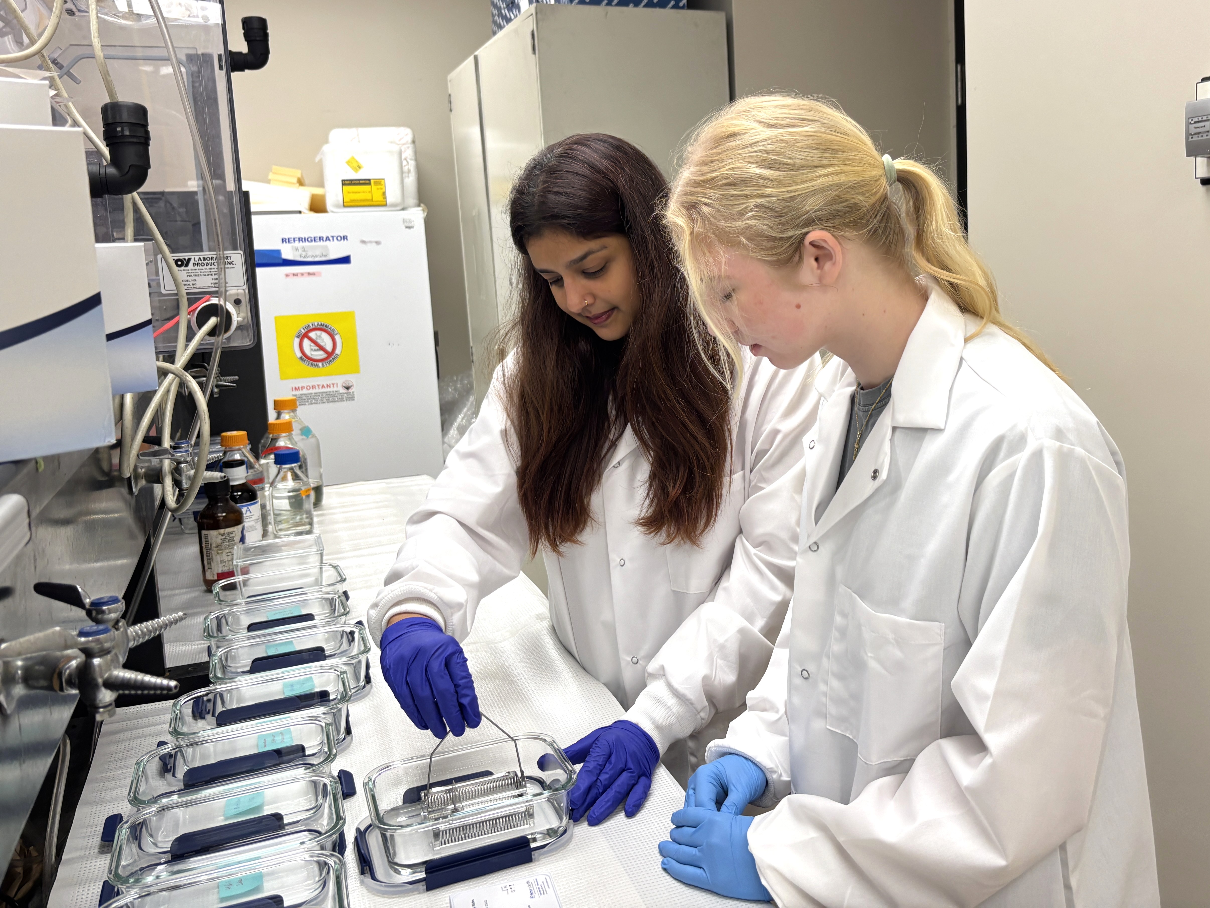 two women in lab coats doing an experiment